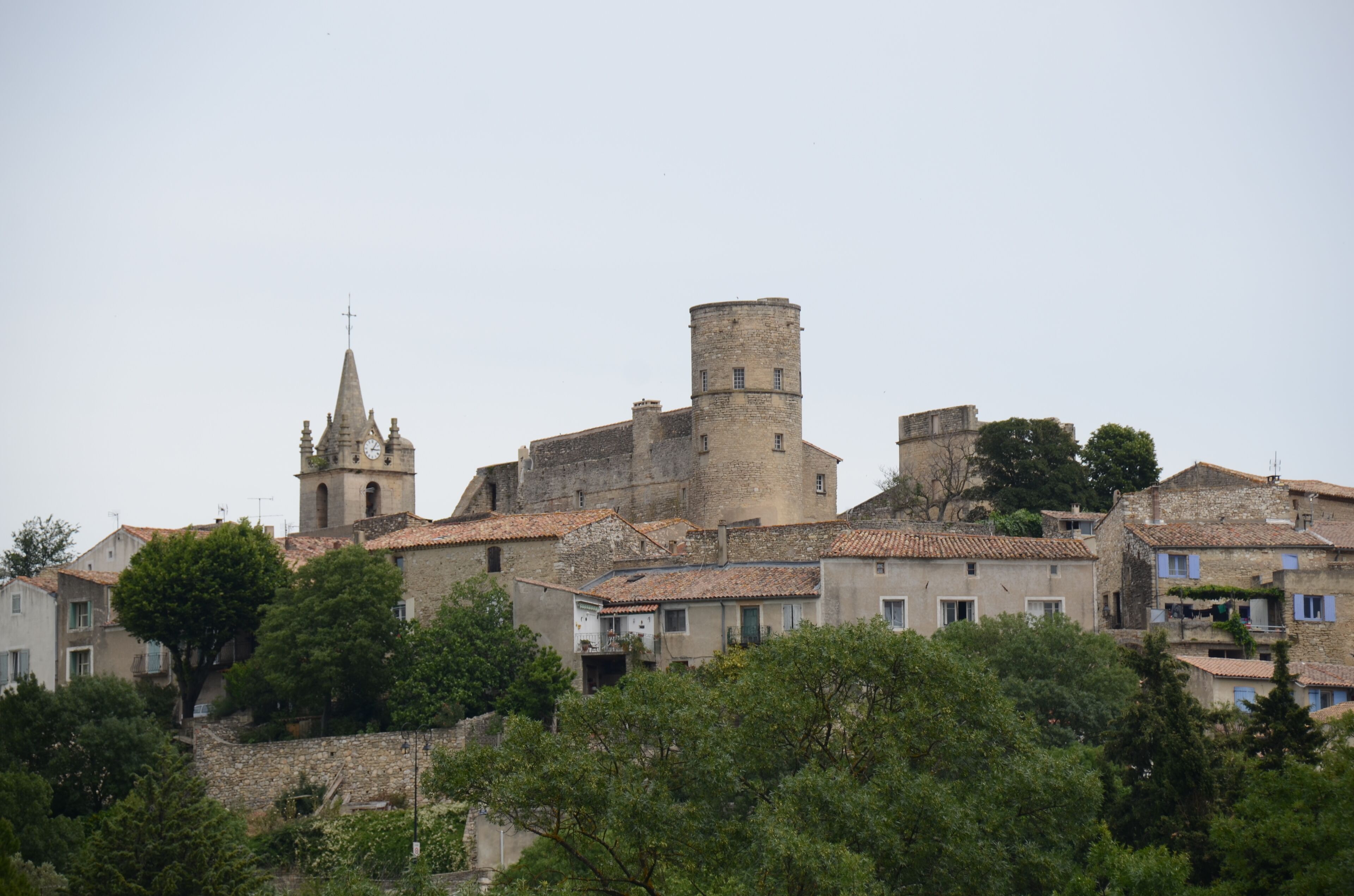 A historic town with a prominent church tower, a large round tower, and traditional buildings with tiled roofs.