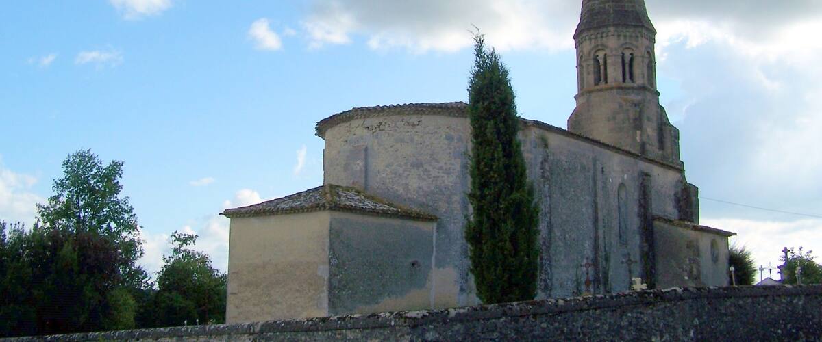 A church with a tall spire and a round building.