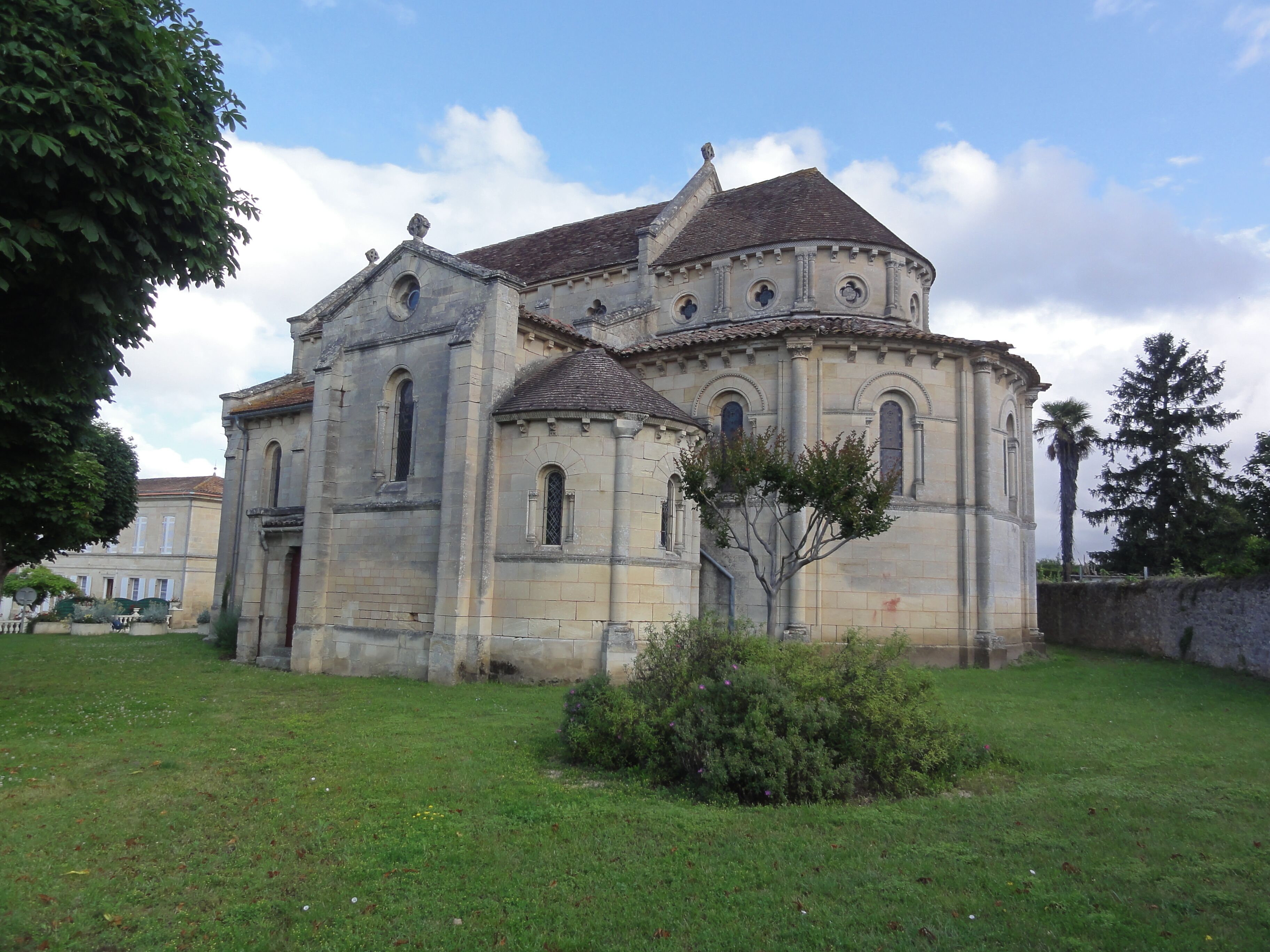 A historic church with a stone facade, arched windows, and a tiled roof.