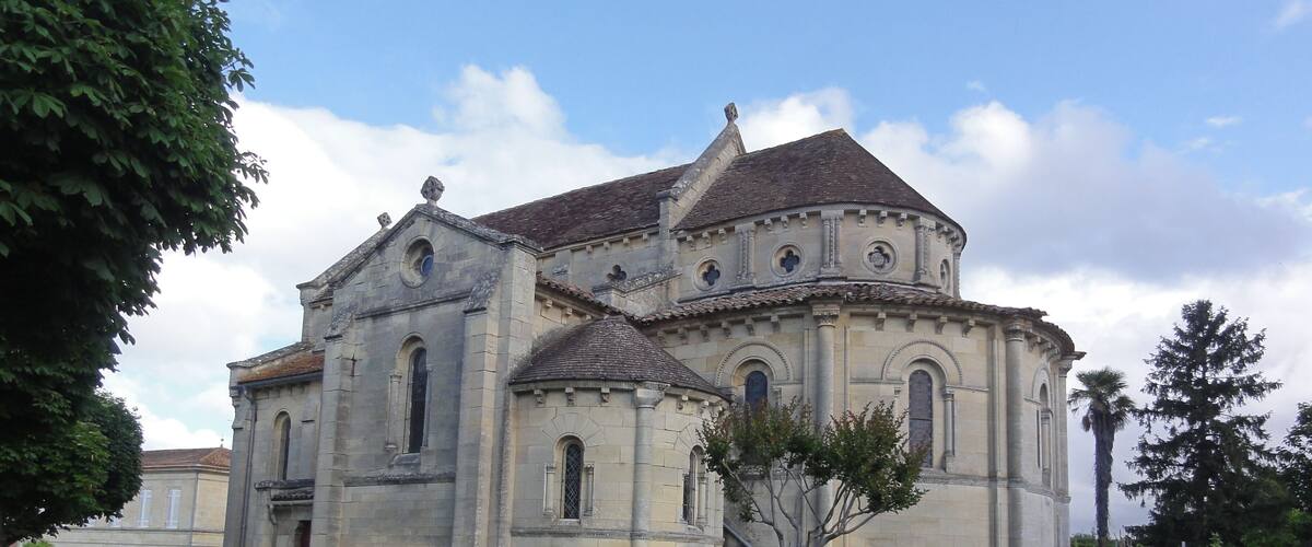 A historic church with a stone facade, arched windows, and a tiled roof.