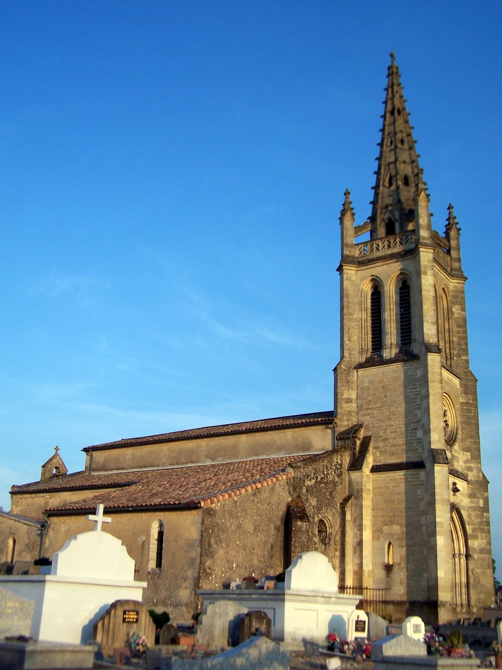 A church with a tall spire and a bell tower.
