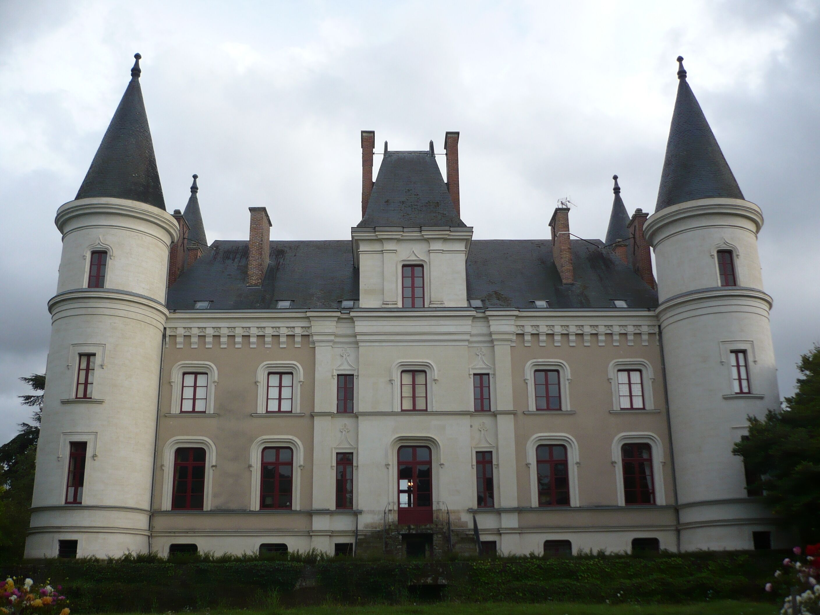 A large, historic building with two prominent towers and a central section with multiple windows.