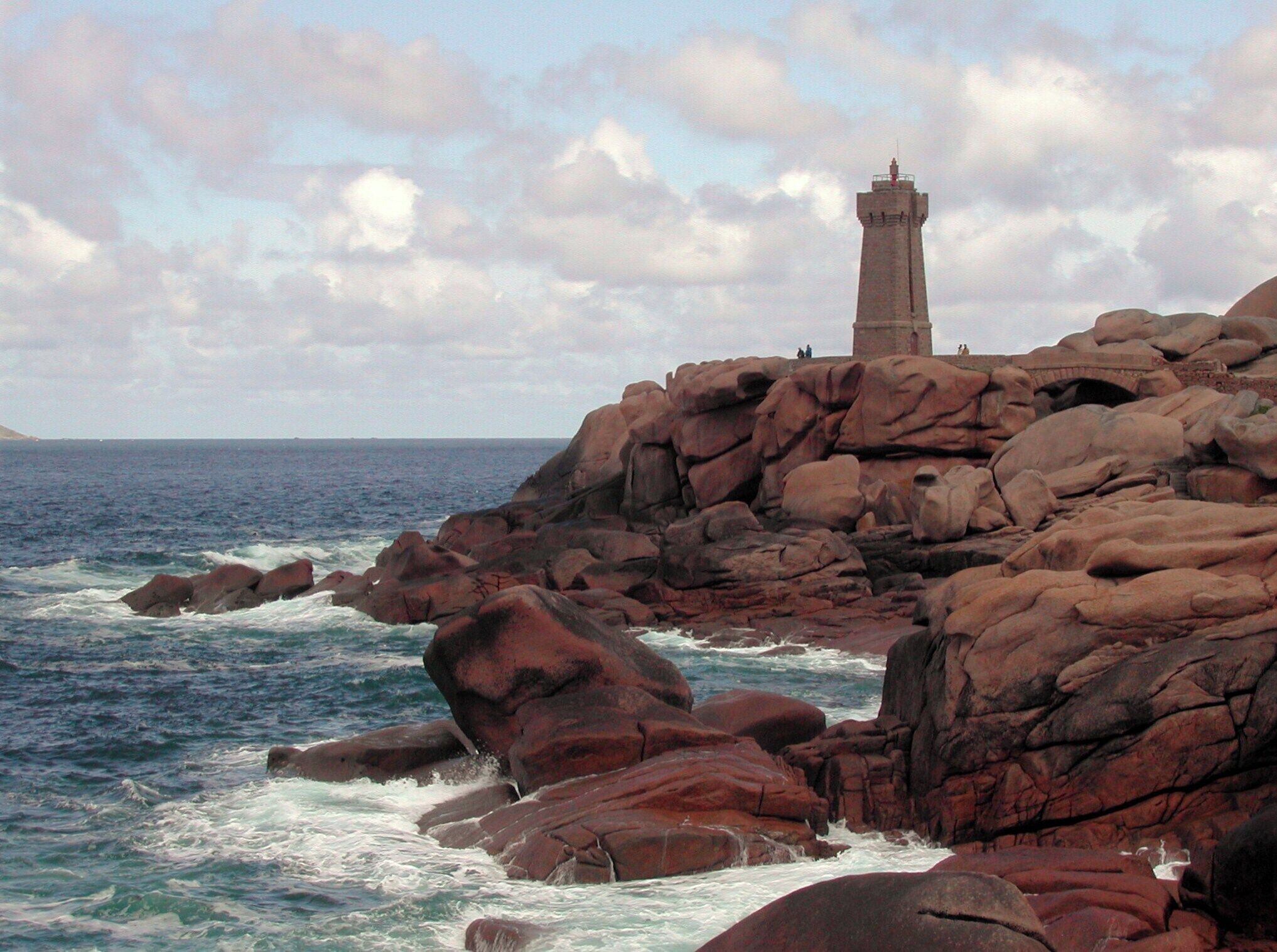 A rocky coastline with a lighthouse on a cliff.