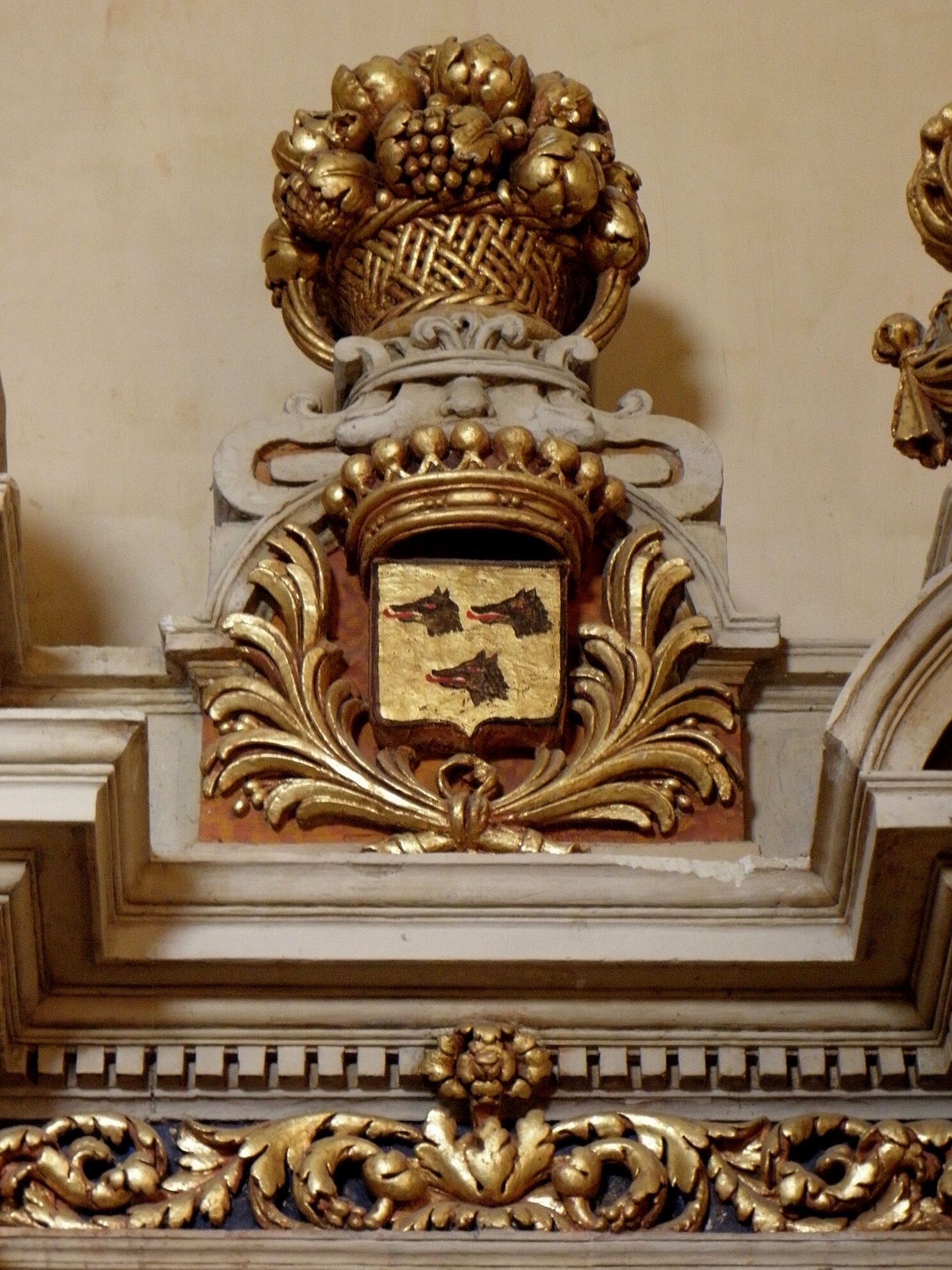Intérieur de l'église Notre-Dame de Brie (35). Autel et retable de Saint-Jean-Baptiste. Armes des Montalembert de Marcillé (D'or à trois têtes de loup arrachées de sable, lampassées de gueules) et corbeille de fleurs et de fruits.
