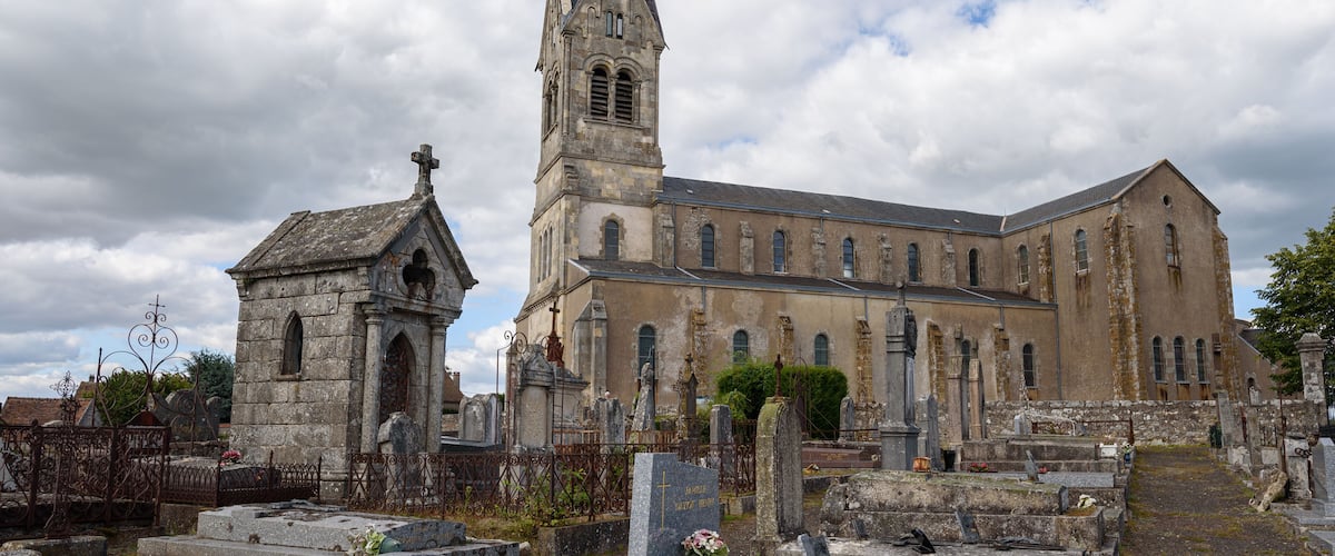 A church with a tall steeple and a smaller adjacent building.