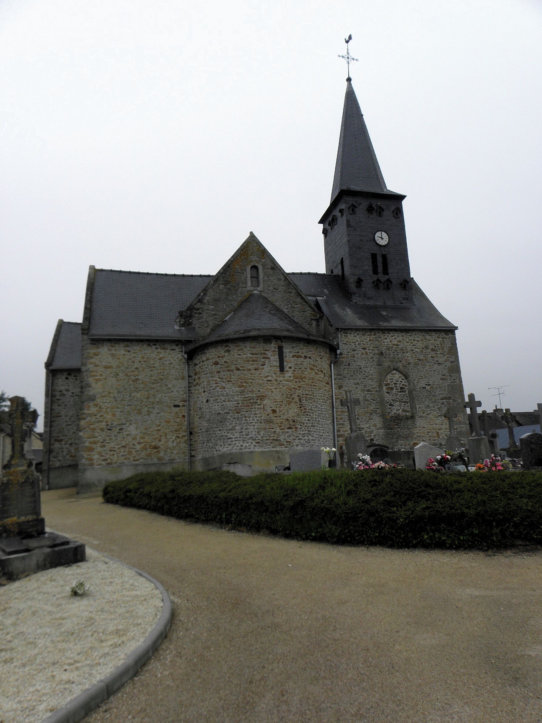 A stone church with a tall steeple and a clock tower.