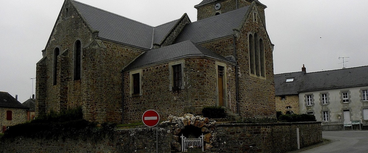 A historic church with a tall steeple and a 'no entry' sign in front.
