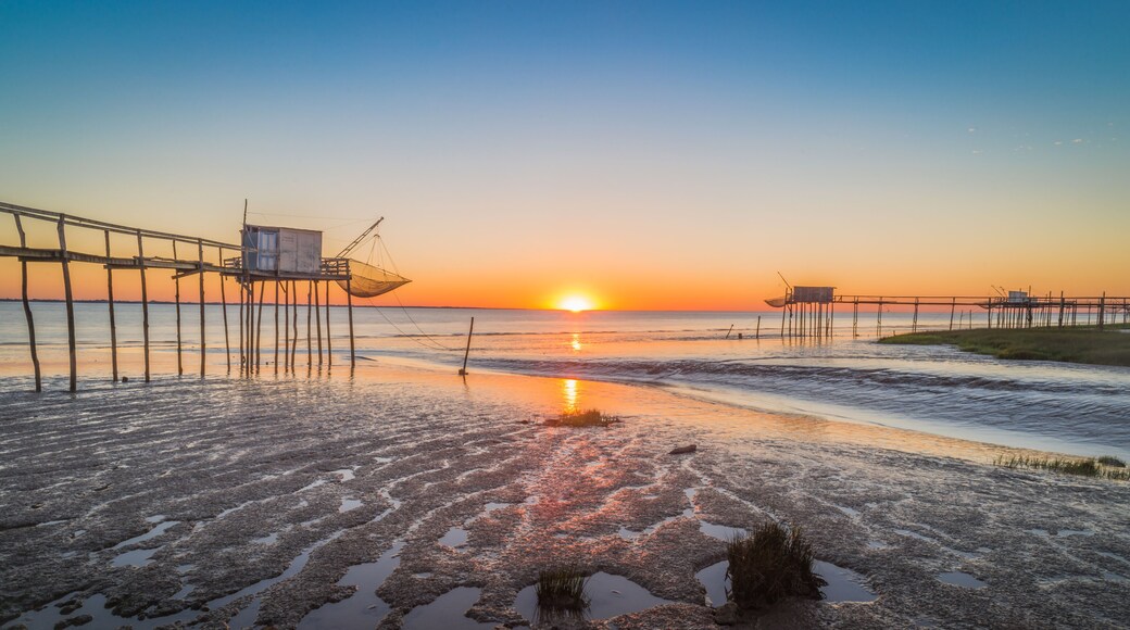 Fishing huts on beach at sunset Atlantic coast of France near La Rochelle