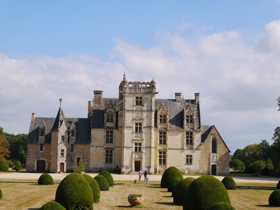 A large, historic stone building with multiple towers and a symmetrical facade.