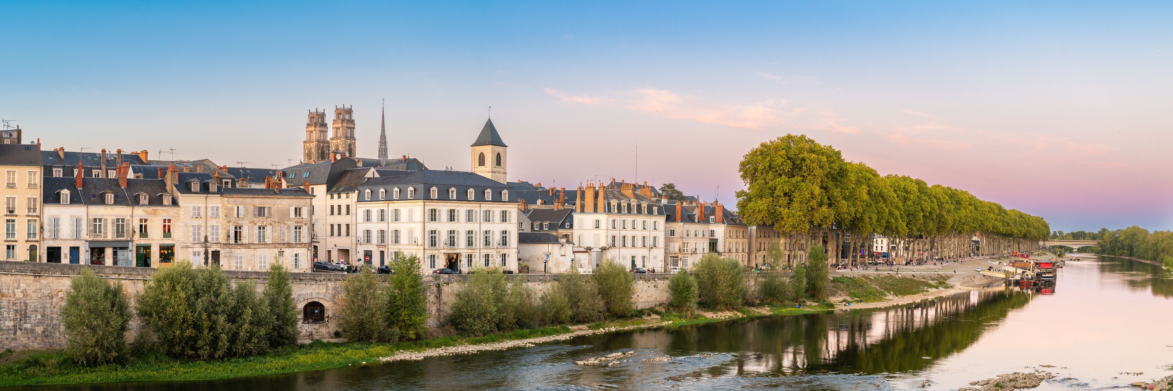 A river with buildings and a bridge in the background.
