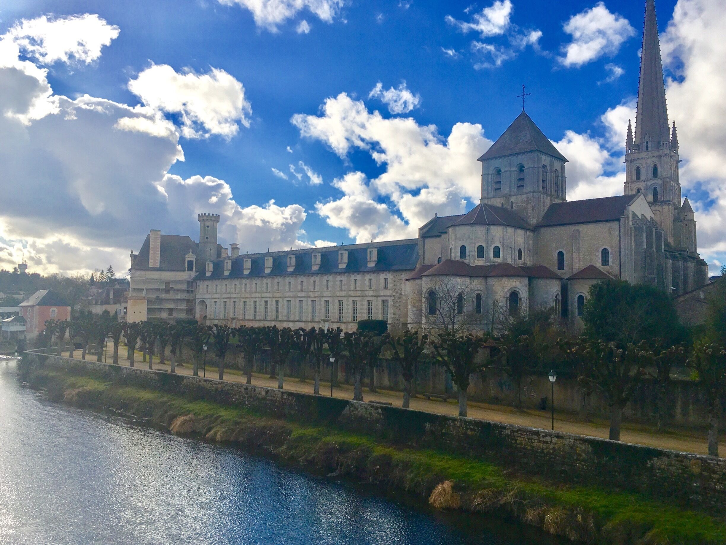A historic building with a prominent tower and a river in the foreground.