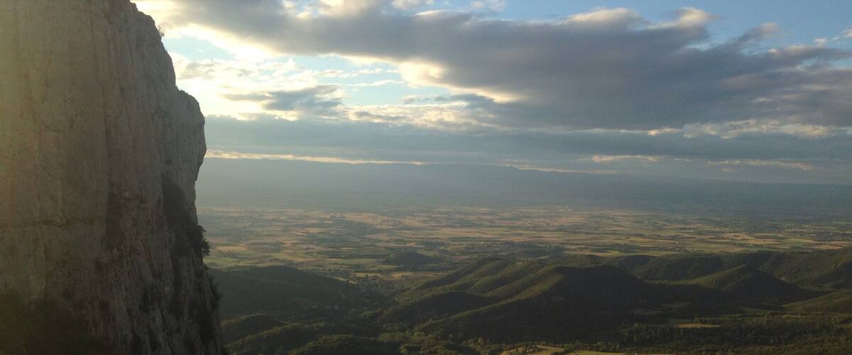 A mountain range with a prominent cliff and a valley below.