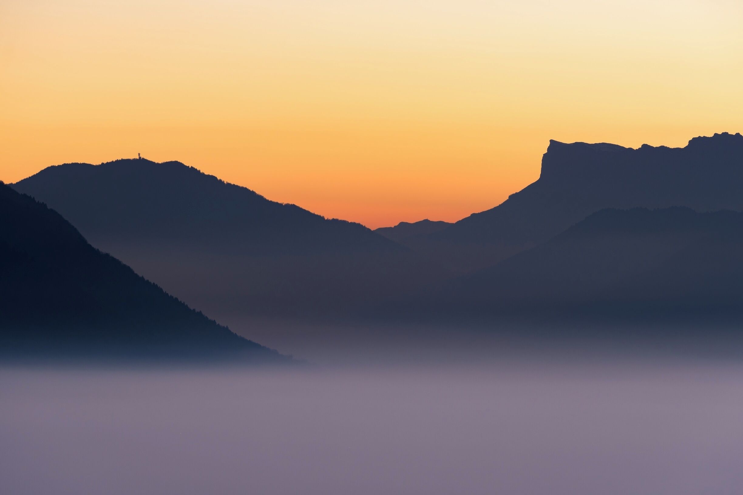 A mountain range silhouette against a sunset sky.