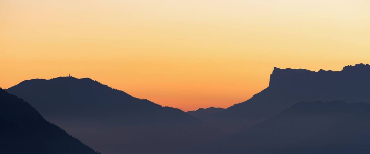 A mountain range silhouette against a sunset sky.