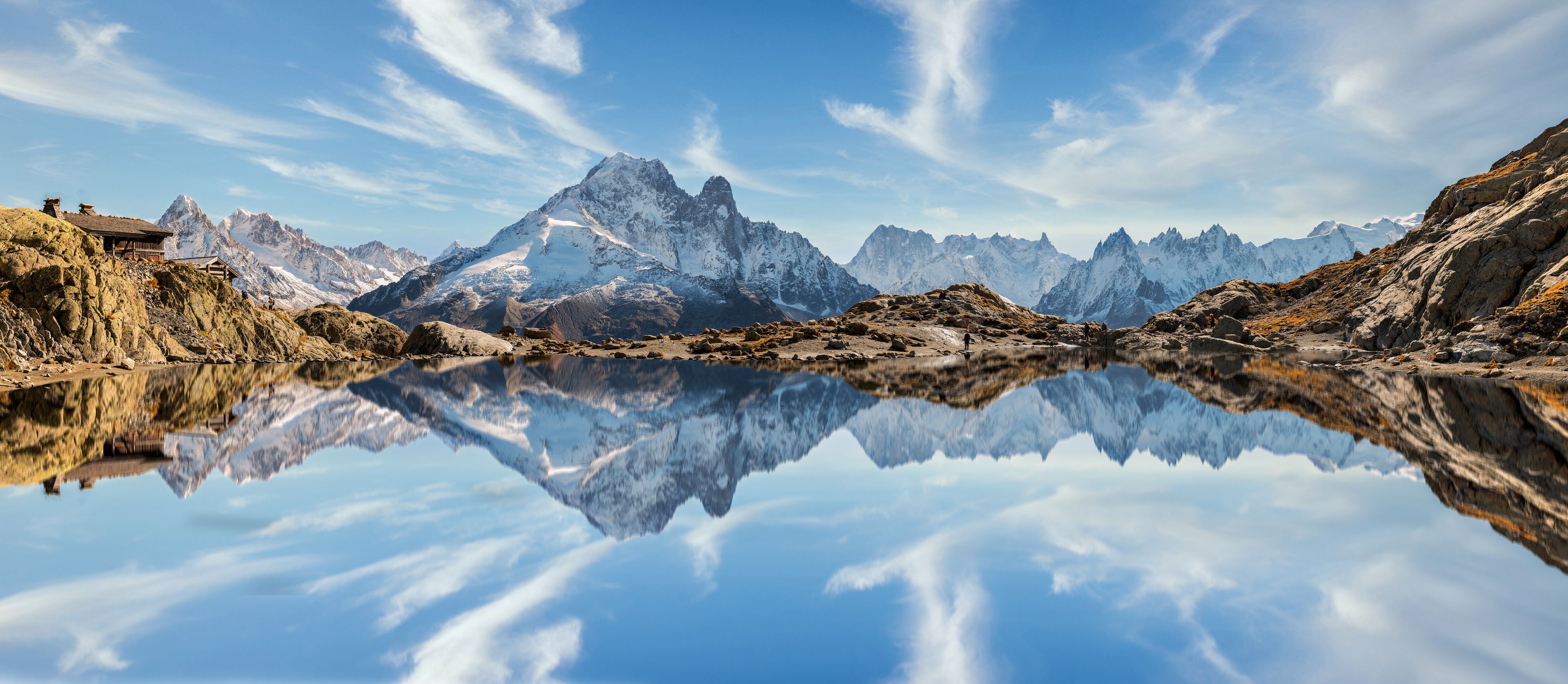 Paisaje montañoso con un lago tranquilo que refleja las cumbres.