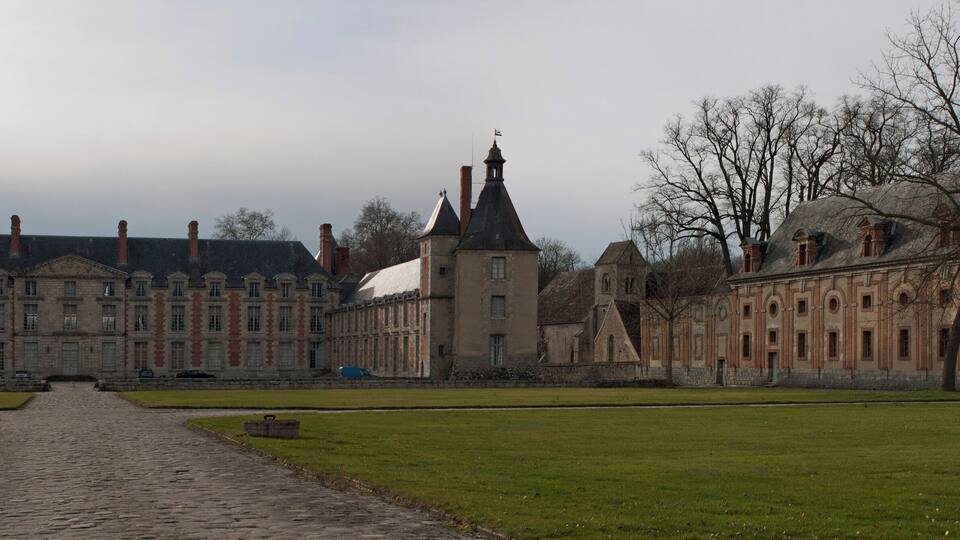 A historic building with a central tower and symmetrical wings.