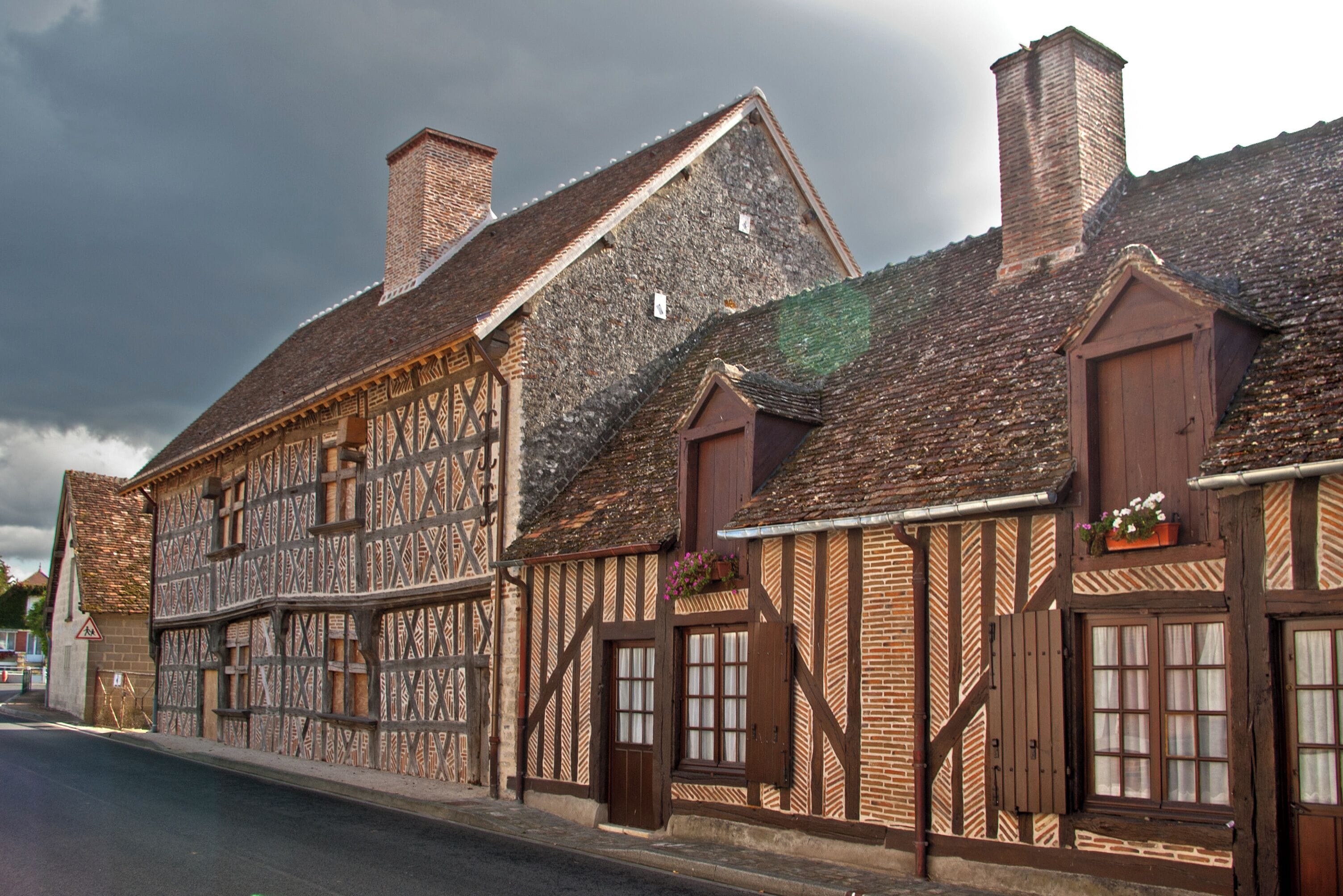 A traditional half-timbered building with a steeply pitched roof and multiple chimneys.