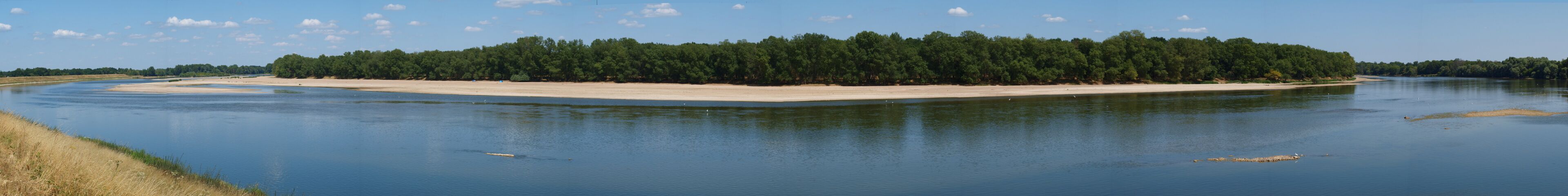 A river with a sandy beach and a forested island.