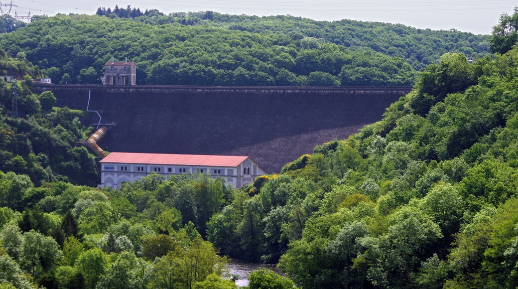 Eguzon-ChantĂŽme (Indre) Le Barrage d'Eguzon, depuis la rive droite.. Barrage hydro-Ă©lectrique sur la Creuse. L'inauguration du barrage a eu lieu le 5 juin 1926. Journal "Le Midi Socialiste" du dimanche 6 juin 1926: "Une Ćuvre cyclopĂ©enne ChĂąteauroux, 5 juin. - Ce matin a eu lieu la cĂ©rĂ©monie de l'inauguration du barrage et de l'usine d'Eguzon, dans l'Indre. Il s'agissait de dĂ©clencher l'usine et de visiter les travaux gigantesques rĂ©alisĂ©s pour constituer une retenue d'eau, lac artificiel qui mesure environ 18 kilomĂštres de longueur, 1 kilomĂštre de large, et contient dans sa vasque environ 54 millions de mĂštres cubes d'eau apportĂ©e par la Creuse. C'est cette eau qui, canalisĂ©e, disciplinĂ©e, viendra en se libĂ©rant actionner les turbines de l'usine et en transformer en Ă©nergie Ă©lectrique transportable Ă des centaines de kilomĂštres. Les travaux entrepris en 1921 par Hydro-Ă©lectrique consistĂšrent dans la construction d'un barrage de 60 mĂ©tres de hauteur et d'une usine de 40.000 kilowats de puissance, sur la Creuse. L'Ă©quipement de cette chute constitue le premier stade dans I'amĂ©nagement de l'Ă©nergie du massif central, dont la plus grande partie doit, ĂȘtre utilisĂ©s pour l'Ă©lectrification des chemins de fer et I'alimentation de la rĂ©gion parisienne. Le barrage d'Eguzon est le plus haut barrage de France. Il a entraĂźnĂ© l'emploi de 210.000 mĂštres cubes de bĂ©ton. Il est susceptible d'Ă©vacuer un dĂ©bit de 2.000 mĂštres cubes. L'Ă©nergie produite par t'usine sera en annee moyenne, de 120 millions de kilowats-heure." La construction du barrage a nĂ©cessitĂ© l'apport de main-d'oeuvre Ă©trangĂšre : "Dâautres types de chantiers comme celui du barrage dâEguzon, projet dâĂ©lectrification dâintĂ©rĂȘt national ont nĂ©cessitĂ© la venue dâune main-dâoeuvre Ă©trangĂšre nombreuse. Ce chantier qui a dĂ©butĂ© en 1916 sâest achevĂ© en 1926. La citĂ© créée alors pour loger les ouvriers rassemble jusquâĂ 1 500 Ă©trangers soit l'Ă©quivalent de la population dâEguzon mĂȘme, originaires dâEurope, dâAfrique et dâAsie. (Histoire et mĂ©moire des immigrations en RĂ©gion Centre - Rapport final mai 2008 - Coordination : Sylvie Aprile, Pierre Billion, HĂ©lĂšne Bertheleu) Le journal "le Dimanche-IllustrĂ© du 7 dĂ©cembre 1930 (N°406) lĂ©gendait une photo du barrage tout neuf : "Oeuvre de titans : le Barrage d'Eguzon. Le barrage d'Eguzon, dans la Creuse, est un des plus reprĂ©sentatif Ă©lĂ©ment de l'Ă©nergie et du gĂ©nie humain: construit en ciment armĂ©, haut de 60 mĂštres, large de 55 mĂštres Ă sa base, il retient les eaux de la Creuse. " Le journal dĂ©voilait la maquette d'un "train mĂ» par une hĂ©lice comme un avion", oeuvre d'un ingĂ©nieur suisse qui espĂ©rait aini atteindre 300 km. Ă l'heure. L'appareil de TSF "radiocinĂ©" coĂ»tait 1540 francs, mais il Ă©tait possible de l'acheter pout 160 francs, et le reste en 12 mensualitĂ©s de 110 francs. Garantie 1 an. On pouvait se procurer l'appareil dans la succursale "radiocinĂ©" de Blois, 20 rue du commerce. La "Nouvelle RĂ©publique" du 20 octobre 2014 pose la question de la rupture du barrage. "Dans l'Ă©ventualitĂ© oĂč le barrage d'Ăguzon venait Ă rompre, un systĂšme d'alerte vient d'ĂȘtre mis en place pour assurer la sĂ©curitĂ© de la population des 21 communes qui pourraient risquer " une inondation Ă cinĂ©tique rapide ". Des sirĂšnes spĂ©cifiques ont Ă©tĂ© installĂ©es."