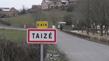 A rural road with a sign indicating 'TAIZÉ' and a yellow sign with 'D 414'.