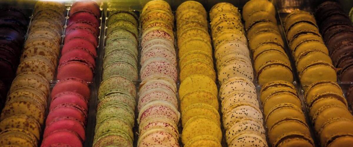 A display of colorful macarons in a glass case.
