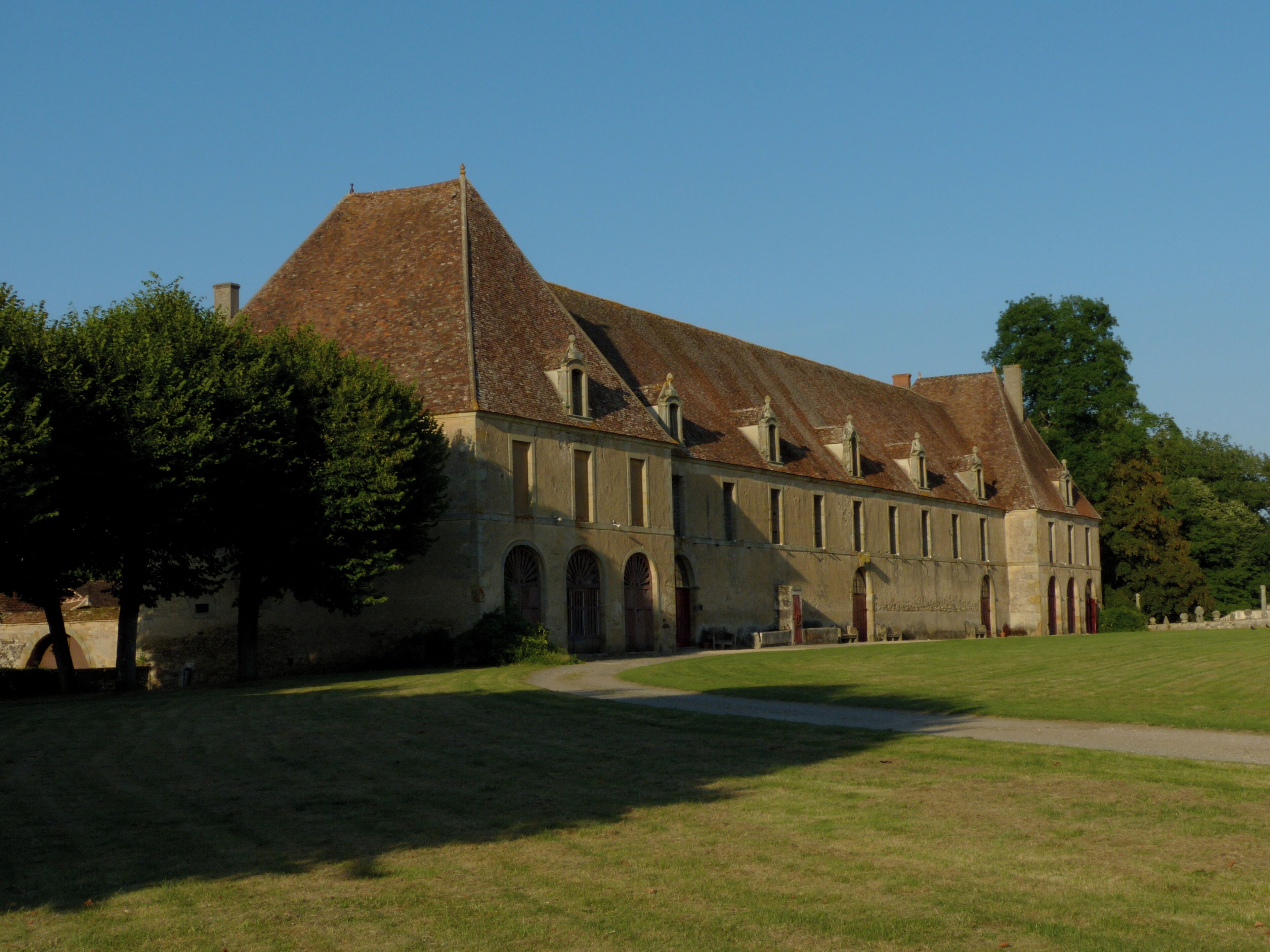 A large, historic building with a steeply pitched roof and multiple arched windows.