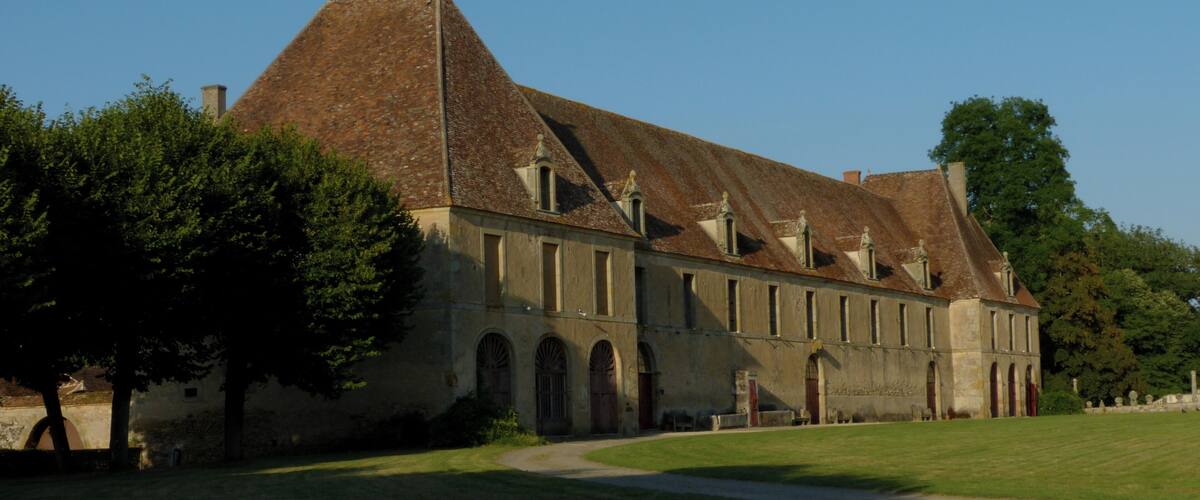 A large, historic building with a steeply pitched roof and multiple arched windows.