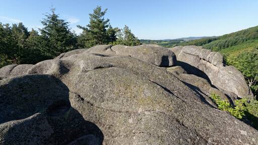 Grandes rocas en un área boscosa con cielo despejado.