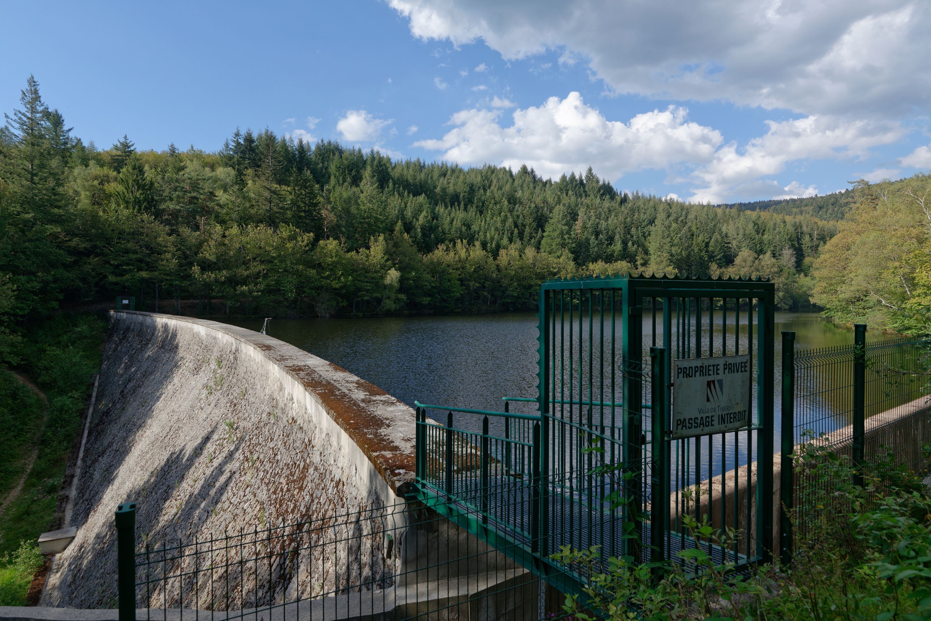 A dam with a sign reading "PROPRIETE PRIVEE" and a fenced area.