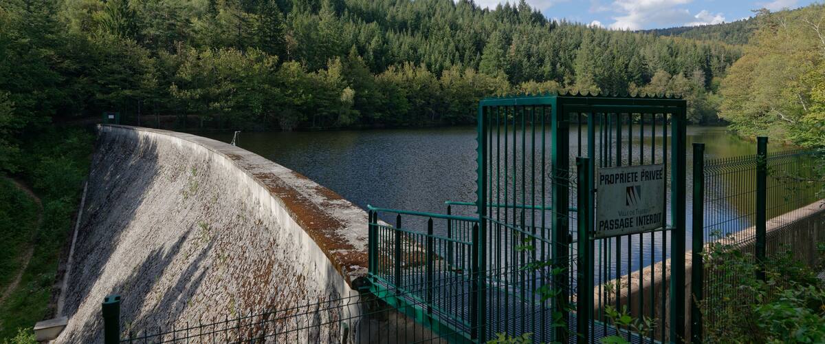 A dam with a sign reading "PROPRIETE PRIVEE" and a fenced area.