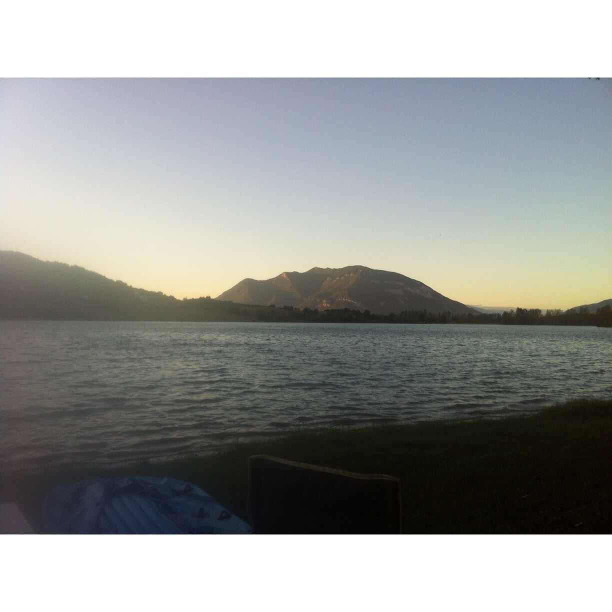 A calm lake with mountains in the background.