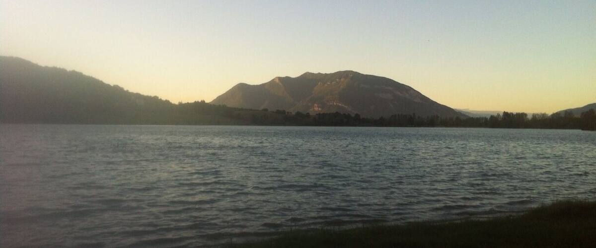 A calm lake with mountains in the background.