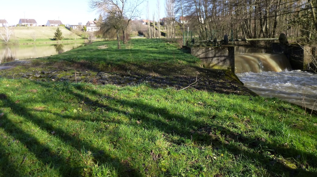 La Chapelle-sur-Aveyron, Loiret, Centre, France. Communal pond, south-east side. The Aveyron river flows on the right here. The pond's overflow runs over the path which goes around the pond, to join with the Aveyron river just after a weir.