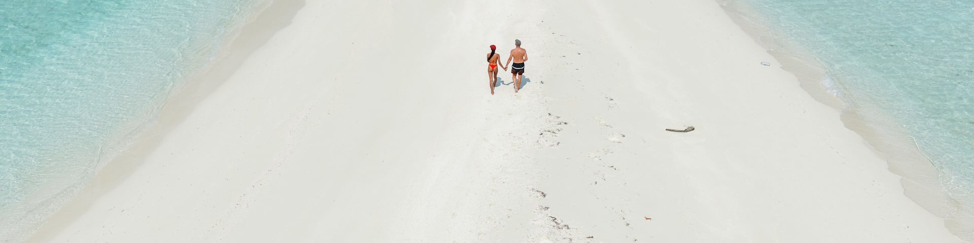 Aerial view of romantic couple on a sandbar in the indian ocean, Maldives
