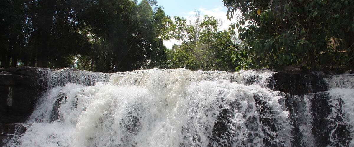 A waterfall cascading over rocks surrounded by trees.