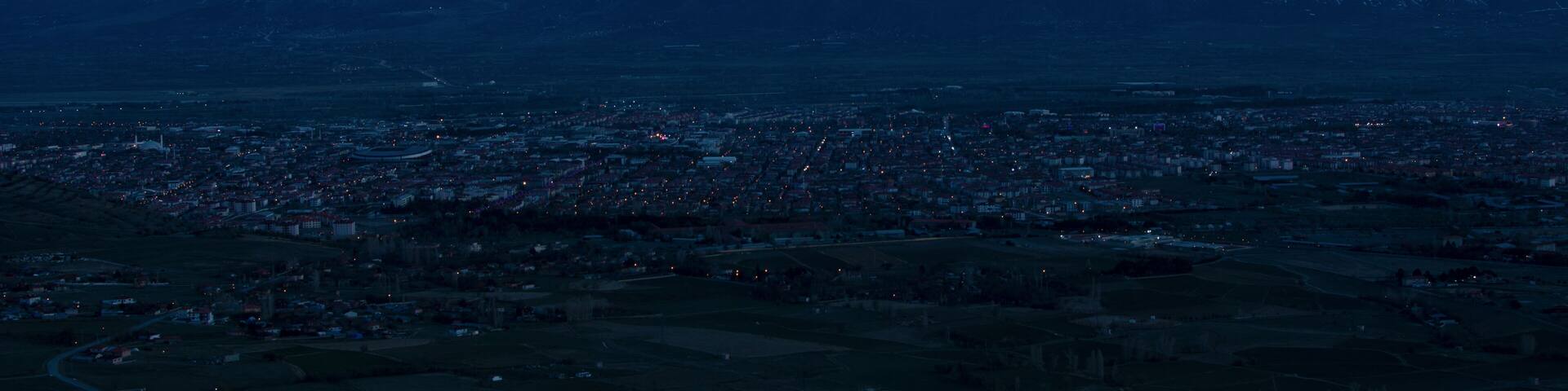 Evening view from the height of the city of Erzincan. Snowy Munzur mountains on the horizon