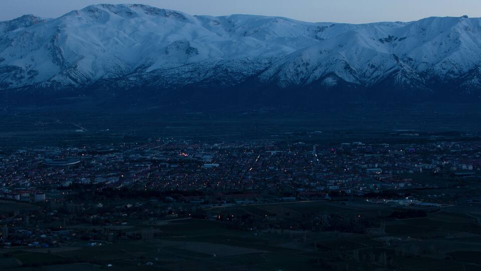 Evening view from the height of the city of Erzincan. Snowy Munzur mountains on the horizon
