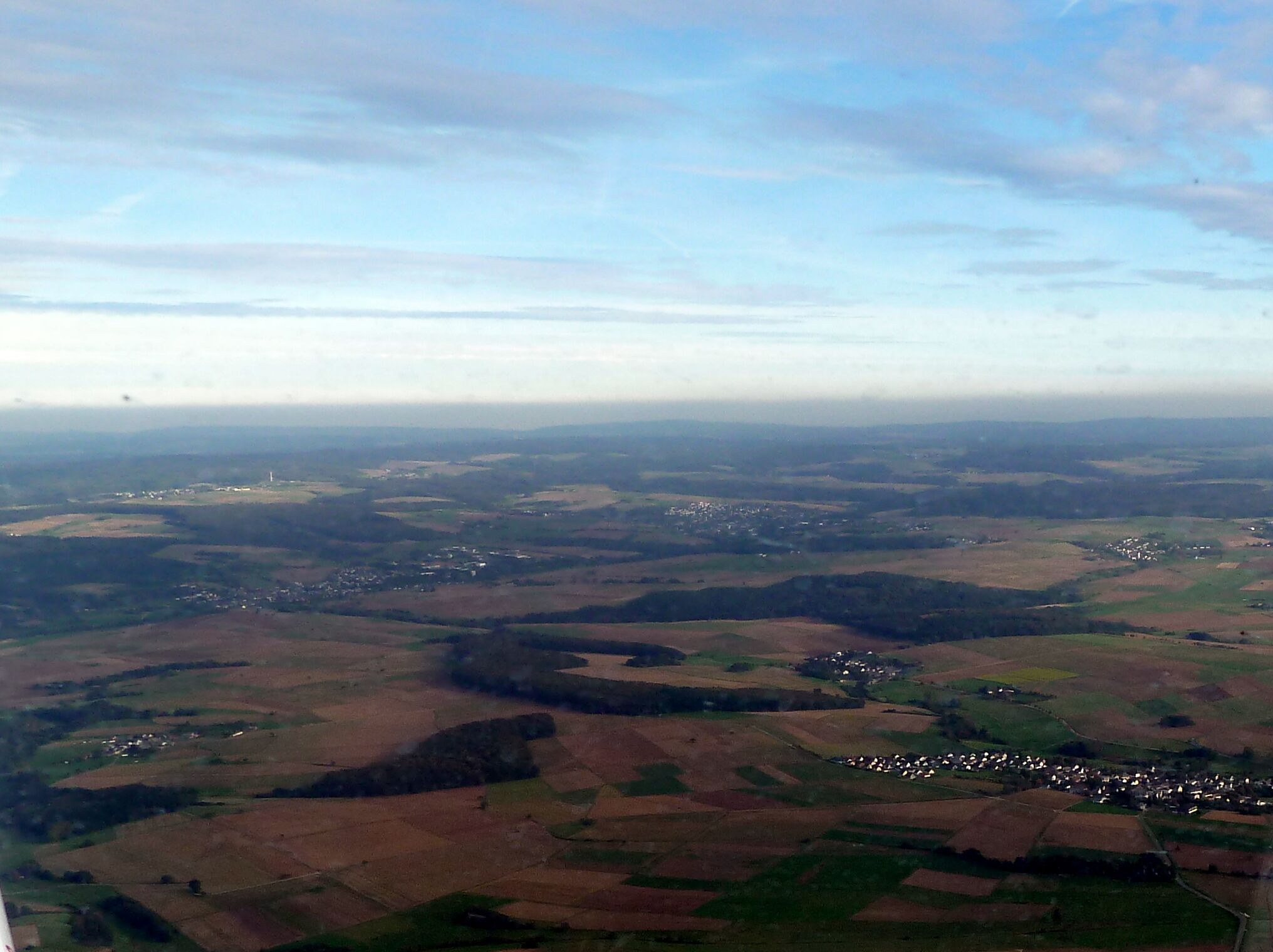A rural landscape with fields, small villages, and a distant tower.