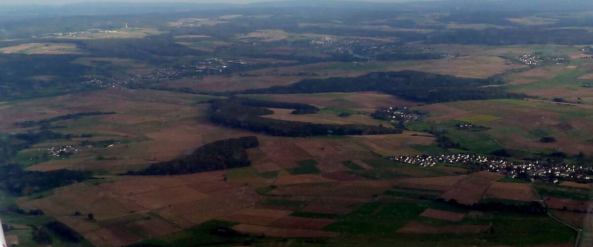 A rural landscape with fields, small villages, and a distant tower.