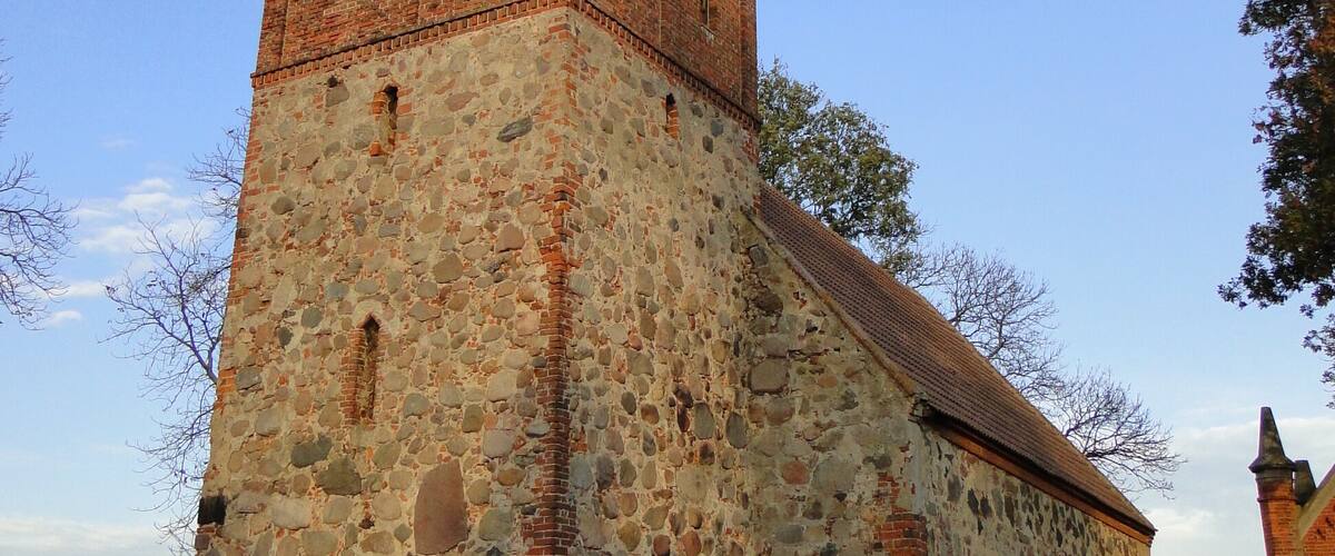 A stone church with a bell tower and a steeple.
