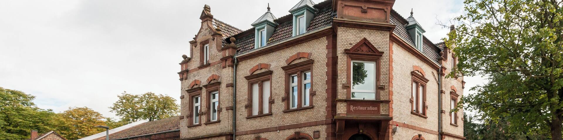 Wohn- und Geschäftshaus, früher Bahnhofsgaststätte; stattlicher Klinkerbau, Neurenaissance, Mansarddach, um 1900, eingeschossiger Anbau