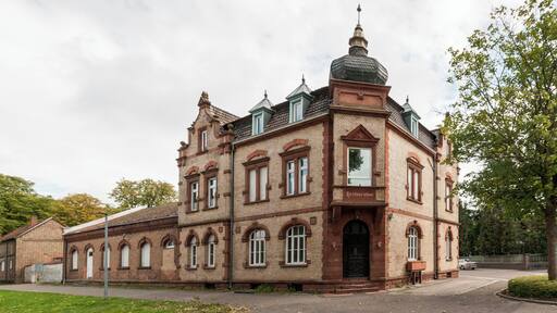 Wohn- und Geschรคftshaus, frรผher Bahnhofsgaststรคtte; stattlicher Klinkerbau, Neurenaissance, Mansarddach, um 1900, eingeschossiger Anbau