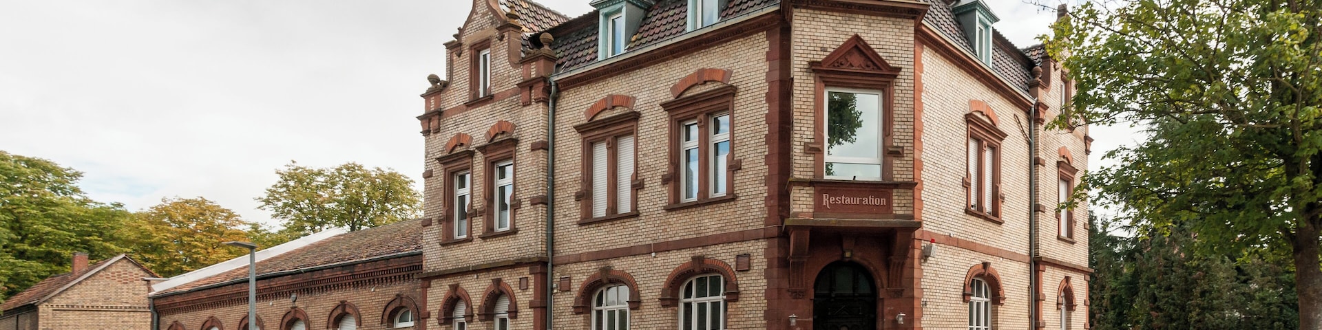 Wohn- und Geschäftshaus, früher Bahnhofsgaststätte; stattlicher Klinkerbau, Neurenaissance, Mansarddach, um 1900, eingeschossiger Anbau