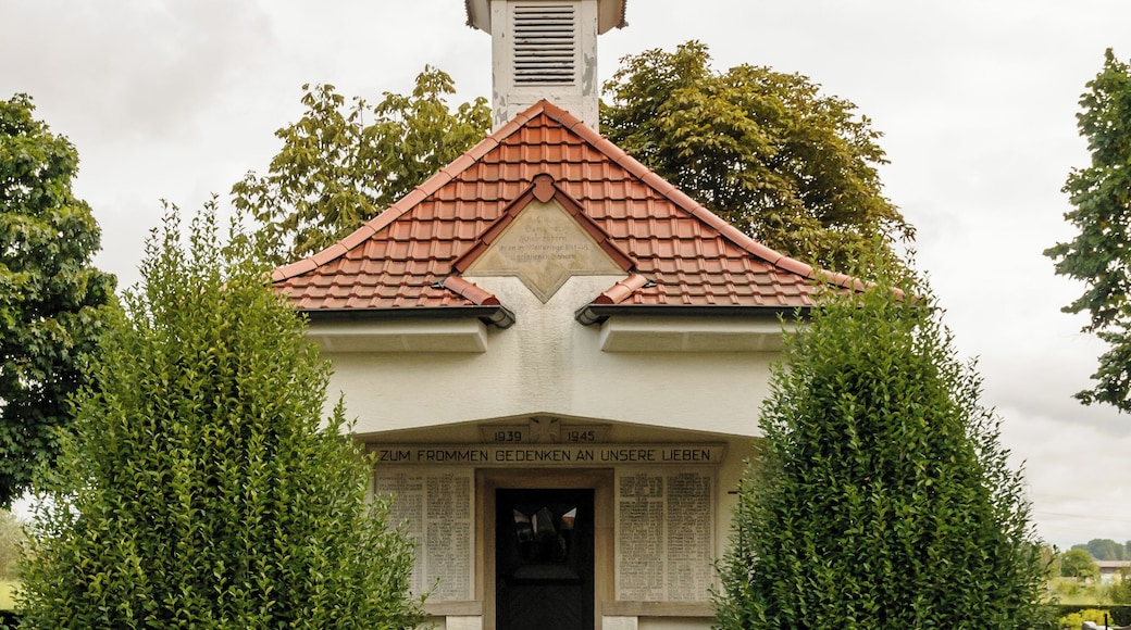 Kriegergedächtniskapelle 1914/18; kleiner Walmdachbau, expressionistisch geprägt; Friedhofskreuz, Rotsandstein, bezeichnet 1844