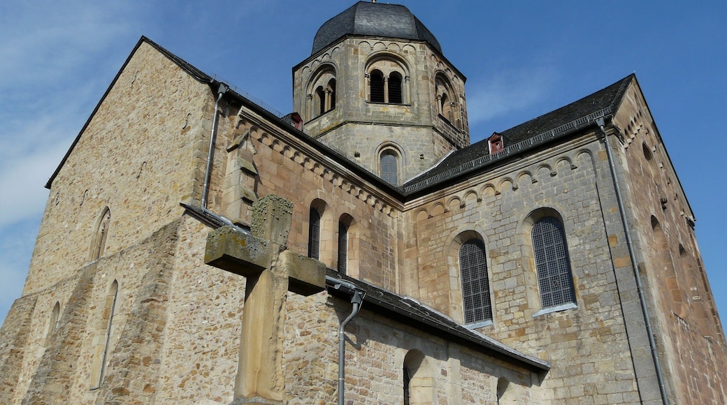 Una chiesa storica in pietra, con un campanile e finestre ad arco.