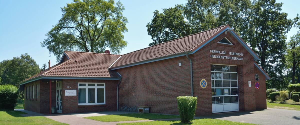 A brick building with a sign reading "Freiwillige Feuerwehr Heiligenstedenkamp" and a wheelchair-accessible entrance.