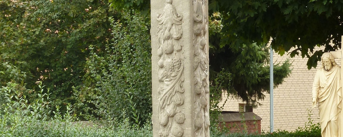 Bildstock von etwa 3,80 m Höhe aus weißem Sandstein neben der katholischen Pfarrkirche St. Johannes Baptist in Seulingen, Untereichsfeld. Datiert 1738.