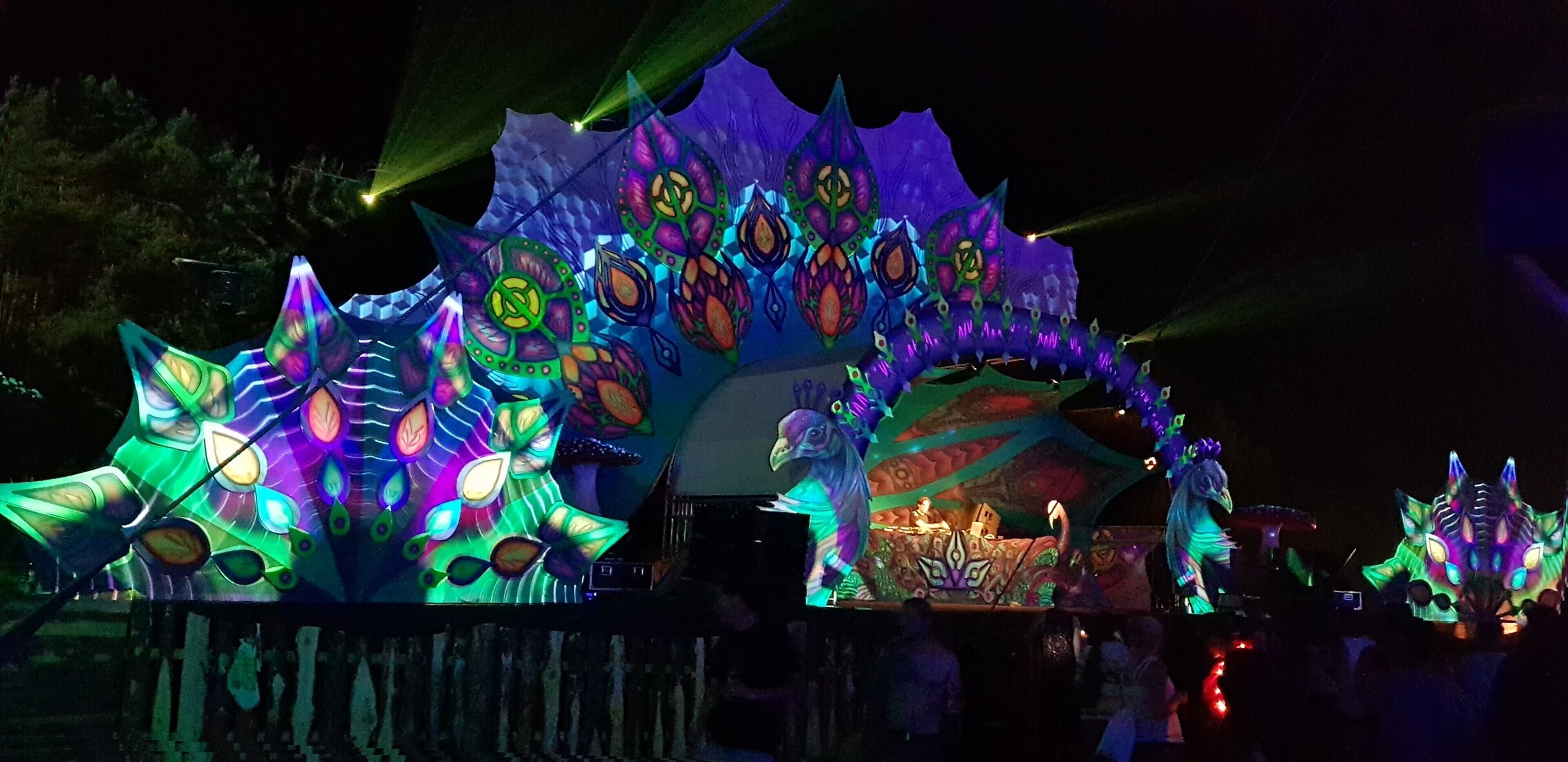 A brightly lit, colorful structure with intricate designs and a stage area.