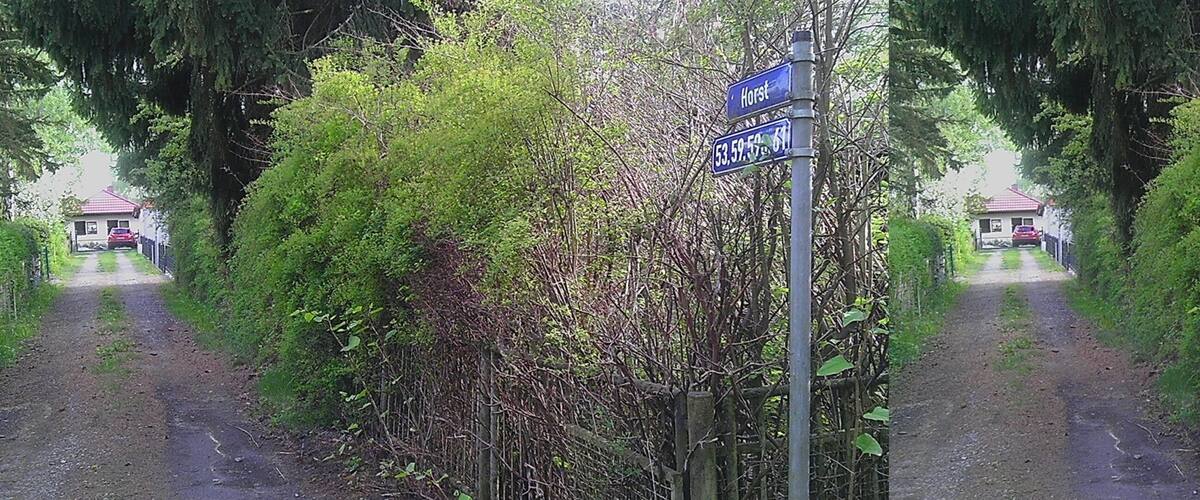 A road with signs indicating 'Hort' and coordinates '53.59.59.61'.