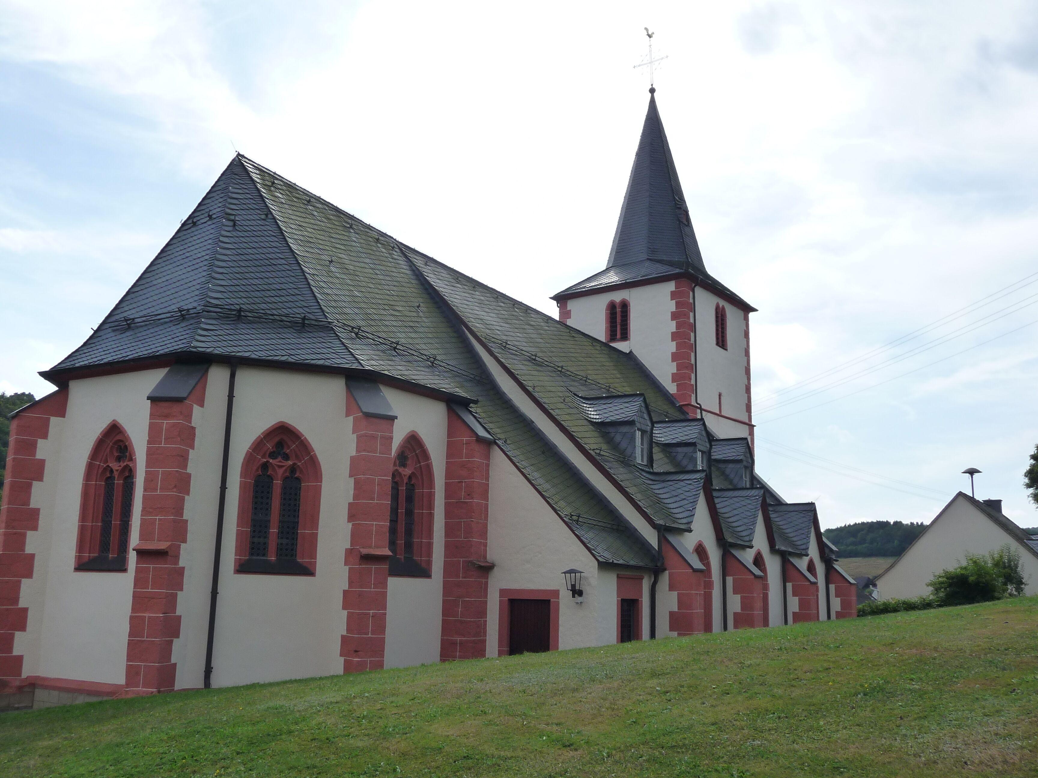 A church with a steeply pitched roof and a tall tower.